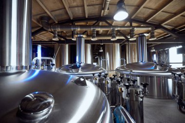 Endüstriyel demleme tankları, yüksek kaliteli bira yapımında kullanılan gelişmiş ekipmanları yansıtacak şekilde hazır bekliyor. Bira, bira fabrikası, üretim, kalite kontrol kavramı