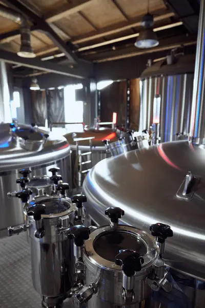 Bira fabrikasındaki tankların ve vanaların parlak yüzeyleri bira yapımındaki temizlik ve hassasiyetin yüksek standartlarını gösteriyor. Bira, bira fabrikası, üretim, kalite kontrol kavramı