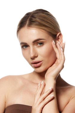 Kusursuz yüzlü, pürüzsüz cilt zarafetini gösteren genç ve güzel bir kadının yakın çekimi. Modern cilt bakımı ve kozmetik ürünlerinin etkisi. Sağlık, cilt bakımı ve sağlık kavramını kabul et