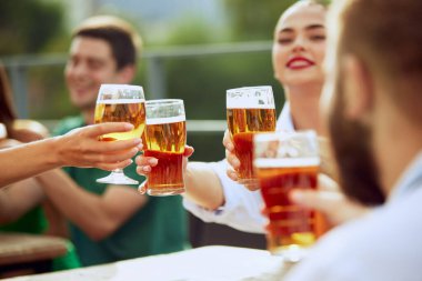 Bar terasında oturan, içki içen, uzun yıllar sonra buluşmayı kutlayan bir grup arkadaş. Neşeli bir atmosfer. Cuma havası, kutlama, öğle tatili ve Ekim Festivali kavramı.
