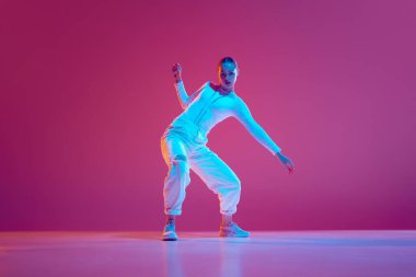 Ritmin ve tarzın göstergesi. Genç yetenekli kız, hareketli dans, antrenman, pembe arka planda hip-hop performansı. Serbest stil dansı, modernlik, şehir kültürü, gençlik kavramı