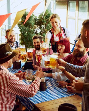 Geleneksel bira festivali. Bir grup neşeli insan, barda bira içip eğlenen kadın ve erkekler. Ekim Festivali, festival, parti, bira fabrikası, gelenek kavramı