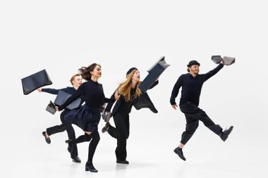 Mega sake alışverişine çıkmış. Siyah kıyafetli bir grup insan beyaz arka planda izole edilmiş alışveriş torbalarıyla koşuyor. Alışveriş, satış, Kara Cuma, moda, tatil kavramı