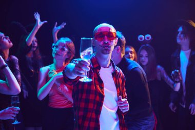 Komik palyaço makyajıyla neşeli bir şekilde dans edip içmeye odaklan. Cadılar Bayramı kutlaması için gece kulübünde toplanan arkadaşlar. Cadılar Bayramı kavramı, tatil, parti, eğlence