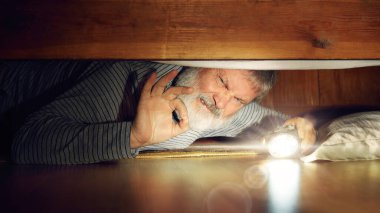 Duygusal son sınıf öğrencisi yatak odasında yerde yatıyor, el feneriyle yatağın altına bakıyor, kayıp eşya buluyor, iğrenç duygularla bakıyor. İnsan duyguları kavramı, ürkütücü bir tatil.