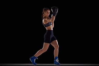 Aparkat. Formda vücutlu, boksör hareketli, eğitimli, siyah stüdyo geçmişine karşı savaşan atletik genç bir kadının tam boy görüntüsü. Spor anlayışı, hobi, aktif ve sağlıklı yaşam tarzı