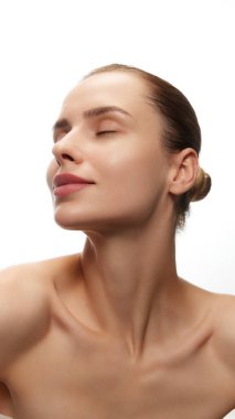 Kendini sevme ve önemseme. Güzel bir genç kadının portresi pürüzsüz, lekesiz, temiz ciltli, makyajsız, beyaz arka planda izole edilmiş. Doğal kadın güzelliği, cilt bakımı, kozmetik ve kozmetik.