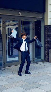 İş teklifi alıyorum. Resmi olarak mutlu bir adam elinde sözleşmeyle ofisten çıkıp yeni iş pozisyonunu kutluyor. İş kavramı, başarı, başarı, mutluluk