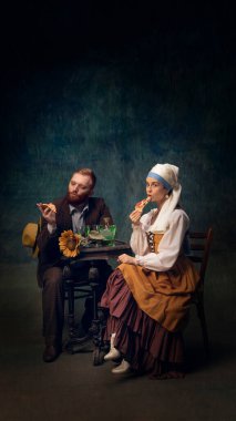 Oturan, içen ve pizza yiyen kadın ve erkeğin sinematik portresi. Van Gogh ve beyaz incili kız modern yemekte. Sanat kavramı, dönem karşılaştırması, yaratıcı vizyon, reklam