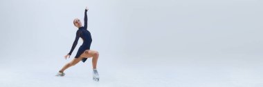 Genç kız, hareket halindeki artistik patinajcı, çarpıcı bir hareketle, beyaz arka planda izole edilmiş buzda gösteri yapıyor. Profesyonel spor anlayışı, performans. Uzayı kopyala, Ad. Pankart