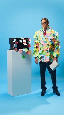 Ciddi bir işadamı, ofis hayatının ezici taleplerini temsil eden evrak çantasıyla yapışkan notlarla kaplı duruyor. İş anlayışı, ofis mizahı, görev yönetimi