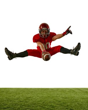 İnsanoğlunun dinamik görüntüsü, sahada hareket eden Amerikan futbolcusu, beyaz arka planda izole edilmiş top ile yükseğe zıplıyor. Spor anlayışı, rekabet, turnuva, oyun. Boşluğu kopyala
