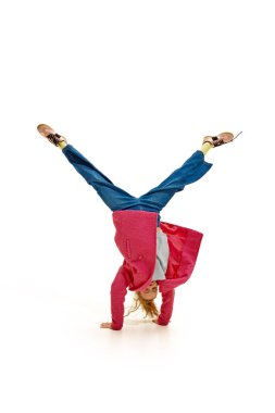 Küçük çocuğun tam boy fotoğrafı, kızın el ele tutuşması beyaz stüdyo geçmişine karşı bacaklarını kaldırması. Tasasız ve çocuksu. İş anlayışı, meslek anlayışı, insan duyguları ve yüz ifadeleri. Ad