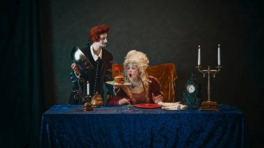 Genç bir adam, peruklu bir kraliyet hizmetçisi, yaşlı bir kadına lezzetli hamburgerler servis ediyor, etkileyici yüzlü bir imparatoriçe, eskimiş geçmişine karşı. Tarih kavramı, çağların karşılaştırması, modern fast food.