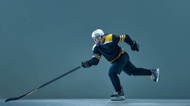 İnsanoğlunun dinamik görüntüsü, profesyonel buz hokeyi oyuncusu hareket halinde, kask ve üniforma giyiyor, maçtan önce antrenman yapıyor. Spor, oyun, turnuva, aksiyon, yarışma kavramı