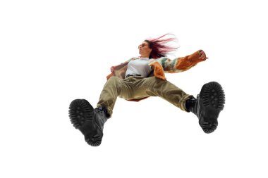 Dinamik, düşük açılı, kendine güvenen, kızıl saçlı, renkli ceket giyen ve beyaz stüdyo arka planında şık pantolonlar giyen genç bir kadın görüntüsü. Moda anlayışı, gençlik kültürü, yaşam tarzı, günlük giysiler.