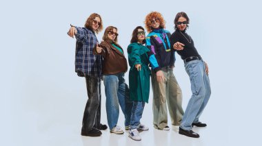 90 'lardan esinlenilmiş bir grup arkadaş, ekose gömlekler, deri ceketler ve beyaz stüdyo arka planında poz veren kot pantolonlar. 90 'ların modası, eski moda, gençlik kavramı