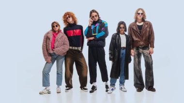 Group of stylish young people, friends wearing retro-inspired outfits from 90s fashion trends, posing against white studio background. Concept of 90s fashion, retro style, youth clipart