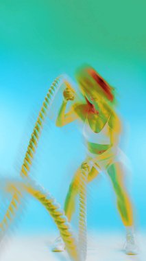 Kavramsal sanat eserleri. Hayat sürekli sürüş. Genç odaklı kadın, eğitime iple bağlanmış, neon renkli ve eğimli. Hareket bulanıklığı etkisi. Spor ve hareket kavramı, modern yaşam tarzı, enerji. Ad