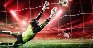 Canlı neon üniformalı kaleci çarpıcı kırmızı ışıkla dolu 3D stadyumdaki yoğun futbol maçında güçlü penaltı atışlarını engellemek için havada dalıyor. Spor, turnuva, yarışma konsepti