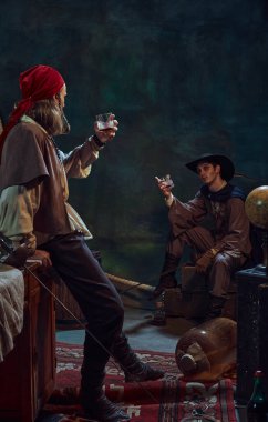 Two pirates raise their glasses of rum in celebratory toast against dark vintage background with retro marine-theme elements. Cheers. Concept of history, adventure, party, friendship clipart