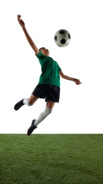 Rekabetçi çocuğun dinamik görüntüsü, hareket halindeki futbolcu, antrenman, göğüs tekmeleyen top, beyaz stüdyo arka planı. Spor anlayışı, eğitim, rekabet, oyun. Dikey resim