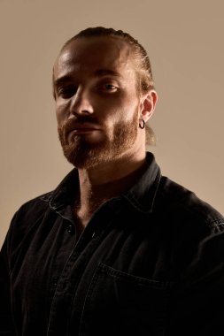 Siyah gömlekli, sakallı, yakışıklı bir adamın portresi. Kendine güveni ve sıcak bir altyapısı var. Erkek güzelliği kavramı, cilt bakımı, moda, sağlık