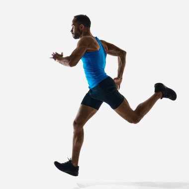 Güçlü erkek sporcuların kısa mesafe koşusu, vücut bütünüyle meşgul, beyaz stüdyo arka planında eğitim görüyor. Spor, rekabet, dayanıklılık, atletizm, spor yaşam tarzı, sağlık