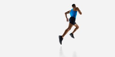 Dinamik alçak açı arka plan görüntüsü spor vücudu olan, koşan, beyaz stüdyo arka planında izole edilmiş eğitimli bir adam. Spor, rekabet, dayanıklılık, atletizm, spor yaşam tarzı kavramı