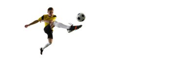 Adamın dinamik görüntüsü, siyah şortlu futbolcu ve hareket halindeki sarı formalı, beyaz arka planda izole edilmiş topa vuran top. Spor anlayışı, aksiyon, rekabet, oyun, aktif yaşam tarzı. Pankart, reklamlar