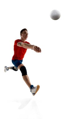 Rekabetçi bir gencin tam boy görüntüsü, üniformalı bir voleybol oyuncusu, beyaz stüdyo arka planında oynuyor. Spor, rekabet, güç, aktif yaşam tarzı, kararlılık kavramı.