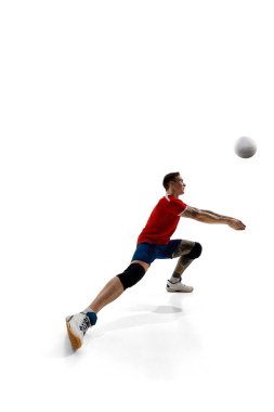 Rekabetçi bir gencin tam boy görüntüsü, üniformalı bir voleybol oyuncusu, beyaz stüdyo arka planında oynuyor. Spor, rekabet, güç, aktif yaşam tarzı, kararlılık kavramı.