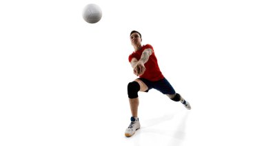 Kararlı atletin dinamik görüntüsü, erkek voleybol oyuncusu maça hazırlanıyor, beyaz arka planda antrenman yapıyor. Spor, rekabet, enerji, güç, aktif yaşam tarzı, kararlılık kavramı