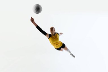 Genç konsantre bir kadının alt görüntüsü, antrenman sırasında hareket halindeki voleybol atleti, beyaz arka planda izole bir şekilde yarışan. Spor anlayışı, aktif ve sağlıklı yaşam tarzı, oyunlar