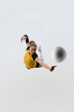 Kazanan gol. Kadın voleybol oyuncusunun oyun sırasında hareket halindeki en dinamik görüntüsü, topa hassas bir şekilde vuruyor, beyaz arka planda antrenman yapıyor. Spor anlayışı, aktif ve sağlıklı yaşam tarzı