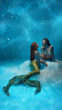 İki tutkulu genç kadın, okyanusun derinliklerinde oturan denizkızları, mavi parlak arka plana karşı sevgi ve şefkat uyguluyorlar. Eşitlik kavramı, çeşitlilik, güzellik, özgürlük, fantezi
