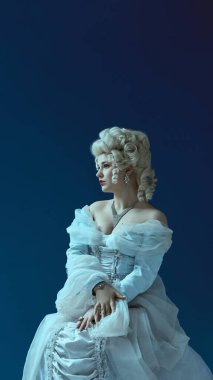 Muhteşem bir duruş. Özel saç stili ve elmas aksesuarlı rococo elbisesi giymiş genç bir kadın. Barok estetiği, kadın asaleti, tarih, karakter, portre fotoğrafçılığı kavramı.