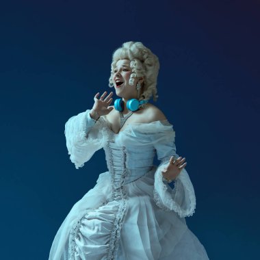 Orta Çağ Düşesi 'nin beyaz elbise ve peruk giymiş, mavi arka planda şarkı söyleyen modern kulaklıklı zarif genç kadın görüntüsü. Devir, güzellik, tarih, sanat, yaratıcılık karşılaştırması kavramı.