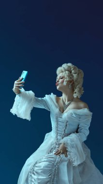 Selfie pozu. Rokoko giymiş genç bir kadının portresi elinde telefonla mavi arka plandaki selfie akımını taklit ediyor. Modern tavırlı ortaçağ karakteri, zamanların şakacı karşılaştırması, moda ironisi..