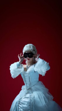 Maskeli balo anı. Pudralı peruklu ve kraliyet cüppeli bayan siyah maske takıyor, cazibe ve gizlilik kanalları açıyor. Tarihi portre, kılık değiştirme, karakter, zarafet, gelenek kavramı.