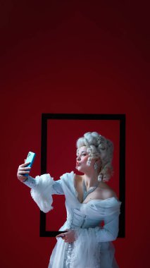 Dijital düşes. Rokoko tarzı ortaçağ kadını elinde akıllı telefon ve sanat tarihi çerçevesinde selfie çekiyor. Teknoloji ve bağcılığın sürreal karışımı, modern ritüeller, kontrast olarak karakter.