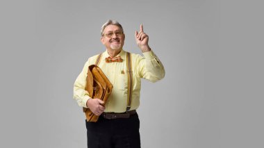 Deri evrak çantası tutan ve gülümseyen yaşlı akademisyen. Fikir anı, önemli bir içgörü. Eğitim, ders, ilham, profesyonellik, hikaye anlatma kavramı