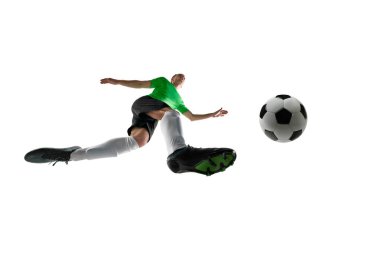 Düşük açılı futbol oyuncusu, siyah ve yeşil formalı, beyaz stüdyo arka planına karşı tüm gücüyle şut atan. Profesyonel spor kavramı, antrenman, turnuva. Ad