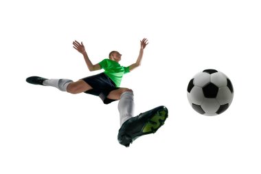 Düşük açılı erkek sporcu, spor üniformalı, futbol oyuncusu beyaz stüdyo arka planına karşı topa vurmak için atlıyor. Profesyonel spor, antrenman, turnuva, enerji kavramı. Ad