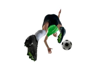 Düşük açılı dinamik bir adam, spor üniforması giymiş, futbolcu beyaz stüdyo arka planına karşı güç kullanarak şut atıyor. Profesyonel spor, antrenman, turnuva, enerji kavramı. Ad