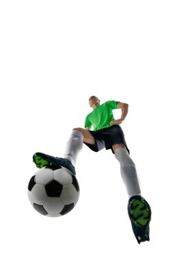 Beceriksiz bir adam, spor üniforması giymiş bir futbolcu, beyaz stüdyo geçmişine karşı uzun paslar hazırlıyor. Profesyonel spor, antrenman, turnuva, enerji kavramı. Ad