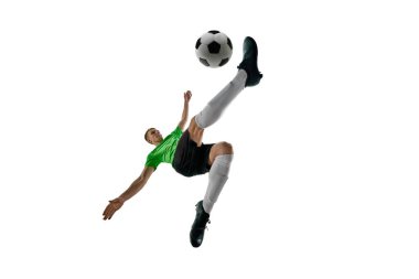 Düşük açılı güçlü bir adam, spor üniforması giymiş, futbolcu beyaz stüdyo arka planına karşı bisiklet tekmesi için atlıyor. Profesyonel spor, antrenman, turnuva, enerji kavramı. Ad