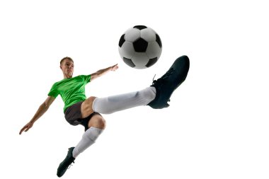 Düşük açılı, spor üniformalı, beyaz stüdyo arka planında hızla ilerleyen bir futbolcu. Profesyonel spor, antrenman, turnuva, enerji kavramı. Ad
