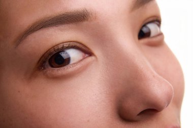 Kusursuz, lekesiz ciltli, kahverengi gözlü, düzgün kaşlı, küçük kusursuz burunlu Koreli bir kadının yakın plan portresi. İdeal özellikler, estetik cerrahi, burun estetiği, güzellik tedavisi, cilt bakımı.