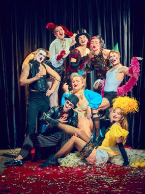 Abartılı ifadeler ve cesur konfeti dekoruyla sahnelenmiş final pozunda dramatik kabare. Sanatçı erkekler ve kadınlar. Kabare, gösteri, sirk, retro, vintage, performans konsepti.